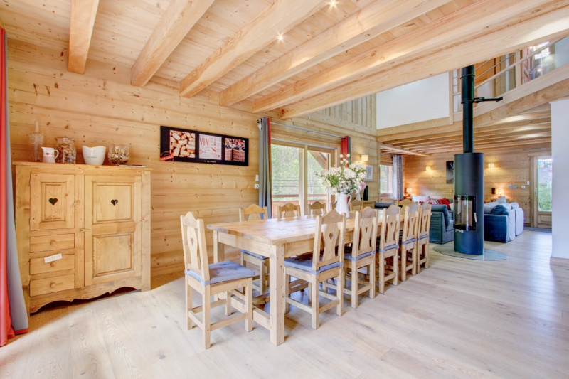 Salle à manger dans un espace ouvert donnant sur poele et salon, décoration bois chaleureuse
